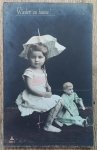 Portret dziewczynki z parasolką i lalką / pocztówka przedwojenna