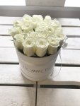 Białe żywe róże w średnim białym boxie