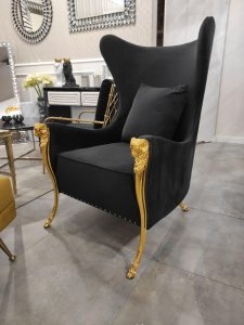 Głęboki wysoki czarno złoty fotel ze zdobieniami