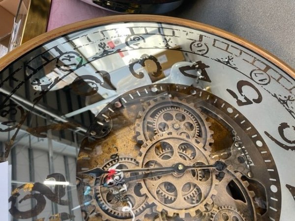 Metalowo szklany lustrzany zegar z widocznym mechanizmem