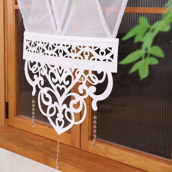 Zbliżenie na ażurowy dół panelu Angelina: precyzyjnie wycięty wzór z białego filcu z dekoracyjnymi koralikami.