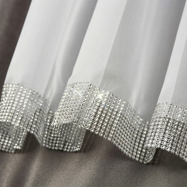 Detal dołu firany glamour: eleganckie wykończenie z szerokim pasem srebrnych cyrkonii.