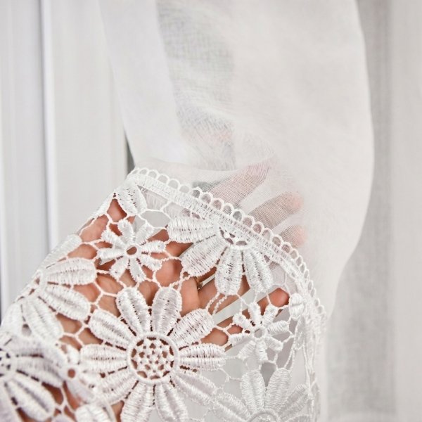 Zbliżenie na ozdobny kwiatowy wzór białej gipiury zdobiącej firanę Megan.