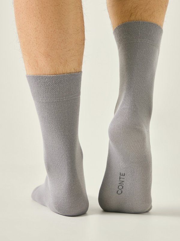 Męskie skarpety CONTE w szarym odcieniu to klasyka męskiej garderoby. Naturalna bawełna, miękki ściągacz i bezszwowe wykończenie zapewniają komfort noszenia przez cały dzień – w pracy, podróży i domu.