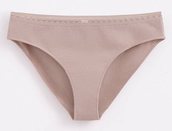 Beżowe majtki damskie o kroju bikini, wykonane z gładkiego materiału. Wzdłuż górnej krawędzi znajdują się delikatne, subtelne zdobienia