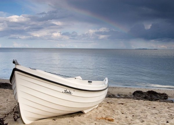 Fototapeta Biała łódź na plaży - 254x183 cm - decoart24.pl